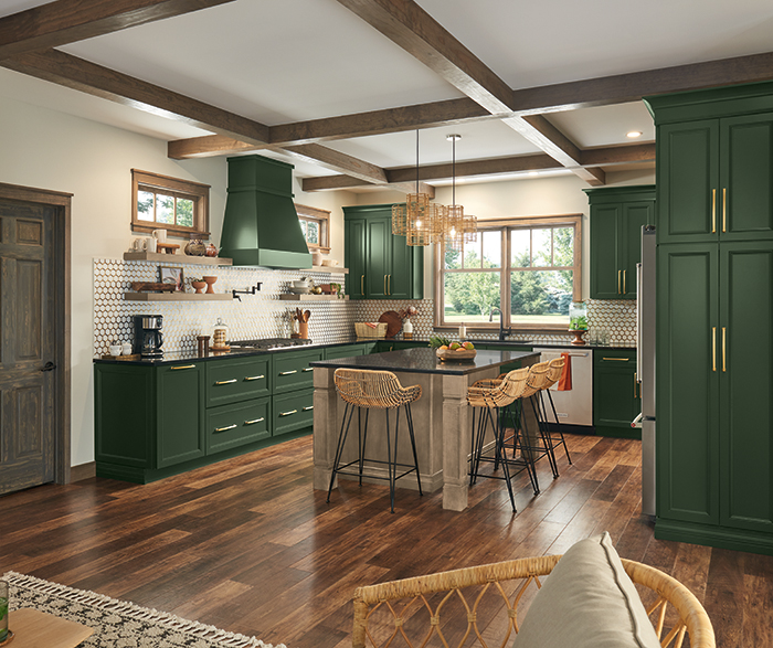 spacious kitchen with deep green cabinetry, a contrasting light gray island, and a rich wooden floor