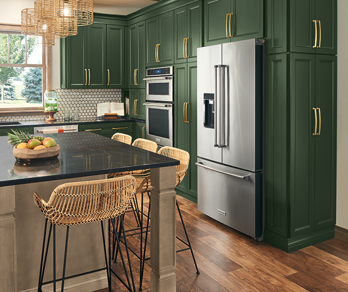 kitchen featuring deep green cabinetry, stainless steel appliances, and a large dark countertop with a marble pattern