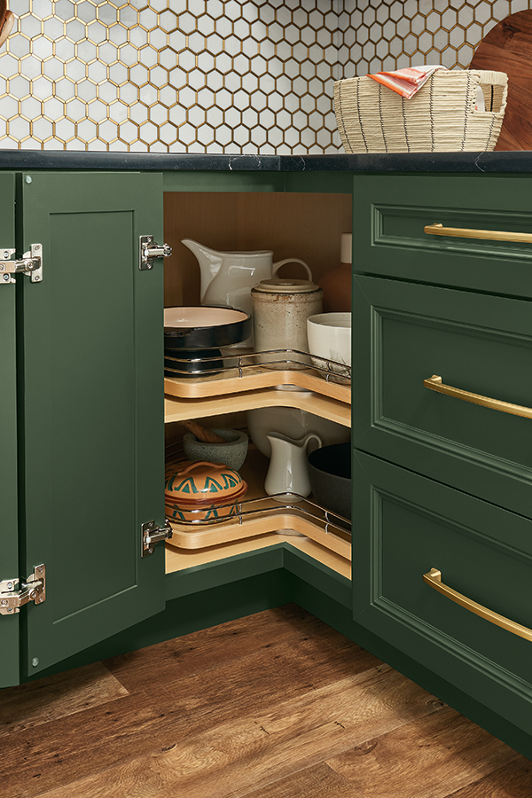 View of a Base Super Lazy Susan with chrome rails inside a deep green cabinet, part of Thomasville Cabinetry's organization solutions.